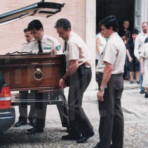 Operarios introducen el féretro de Victoria Kamhi en el coche mortuorio tras la misa córpore insepulto en el Palacio Real, en Aranjuez