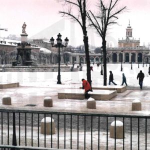 Varias personas junto a  la Fuente de la Mariblanca, iglesia y plaza de San Antonio en Aranjuez tras una nevada