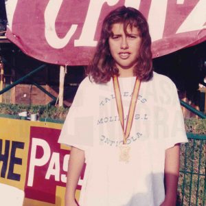 Diana García y otras dos nadadoras en el podio en  una piscina en Puerto Real