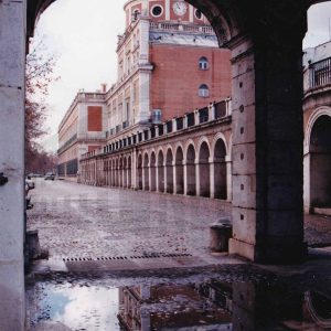 Acceso a la Plaza de Parejas desde las arcadas de las Casas de Oficios y Caballeros por la Avenida de Palacio en Aranjuez tras un día de lluvia
