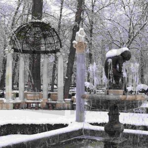 Una persona junto a la Fuente de las Harpías (o del Niño de la Espina) en el Jardín de la Isla de Aranjuez tras una nevada.