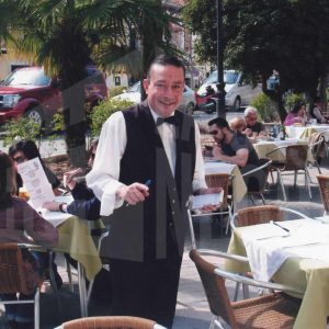Varias personas y un camarero en la terraza de la Cafetería La Italiana de Aranjuez