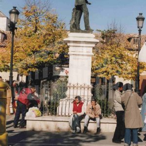 Varias personas alrededor de la estatua de Alfonso XII en la Plaza de la Constitución de Aranjuez