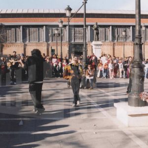 Varios jóvenes tocan la guitarra en el centro de un corro de gente en la Plaza de la Constitución de Aranjuez