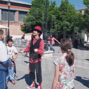 Varios niños observan a unos malabaristas en la Plaza de la Constitución de Aranjuez