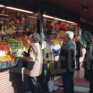 Varias personas en una frutería del patio del Mercado de Abastos en Aranjuez