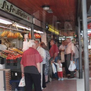 Varias personas en una frutería del patio del Mercado de Abastos en Aranjuez